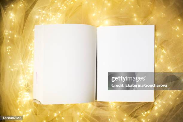 a white empty notebook lies on a sparkling magical new year's background. - glowing book stock pictures, royalty-free photos & images