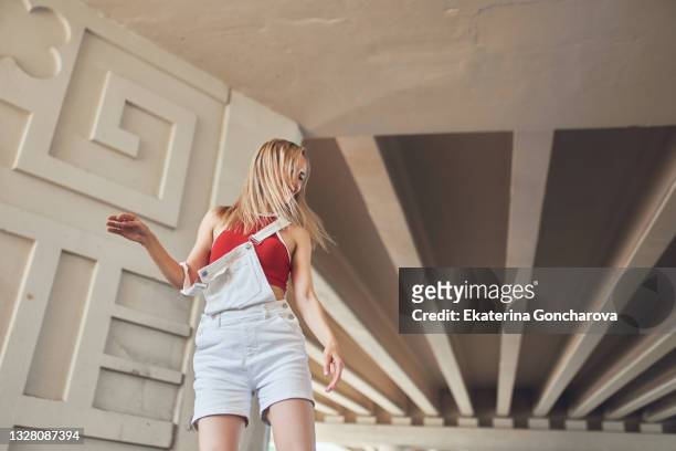 a young beautiful slender woman is dancing the melbourne shuffle dance under the bridge - shuffling stock pictures, royalty-free photos & images