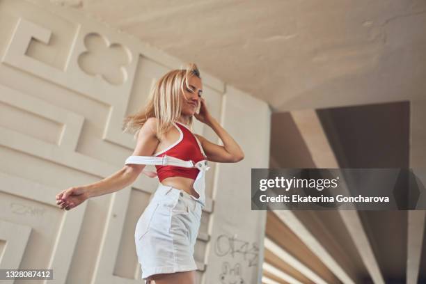 a young beautiful slender woman is dancing the melbourne shuffle dance under the bridge - shuffling stock pictures, royalty-free photos & images