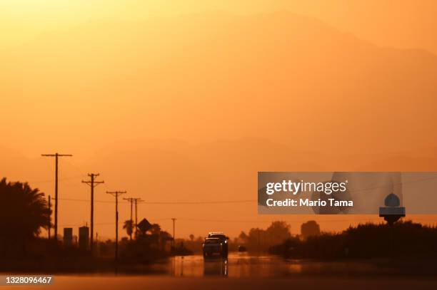 Vehicles are viewed above a 'highway mirage' caused by a thin layer of hot air above the roadway on July 10, 2021 near Thermal, California....