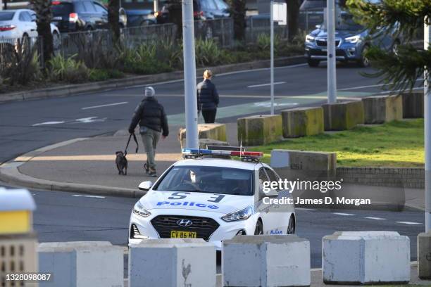 Police car patrols along Bondi Beach on July 11, 2021 in Sydney, Australia. Lockdown restrictions have been tightened across NSW as COVID-19 cases...