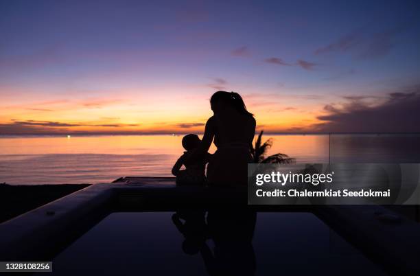 silhouette of mother and daughter during sunrise - hua hin thailand stockfoto's en -beelden