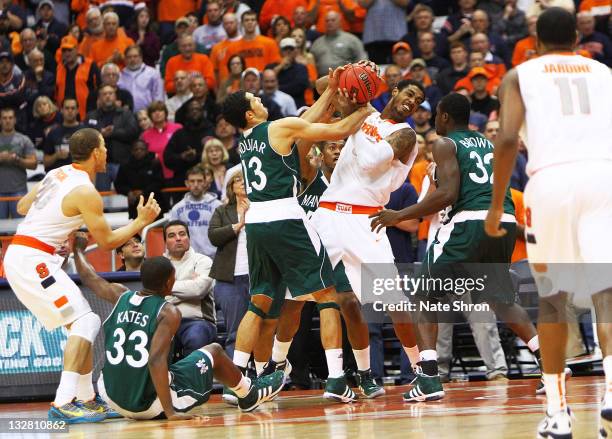 Fab Melo of the Syracuse Orange holds the ball against Emmy Andujar and Rhamel Brown of the Manhattan College Jaspers during the NIT Season Tip-off...