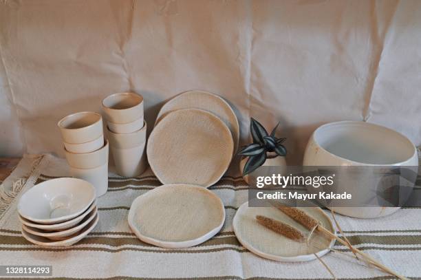 ceramic bowls, glasses, plates, vase, candle holder arranged on a table - earthenware stock pictures, royalty-free photos & images