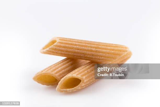 wholemeal pasta penne as close-up shot isolated on white background - whole wheat penne pasta stock pictures, royalty-free photos & images