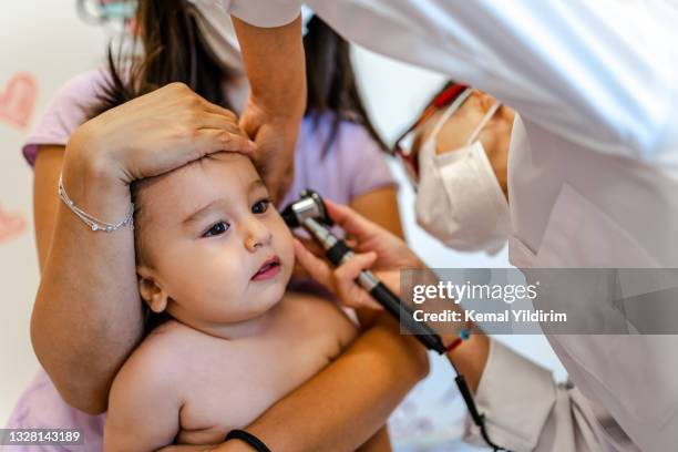 close up of a pediatrician having a check up on her baby patient - baby ear infection stock pictures, royalty-free photos & images