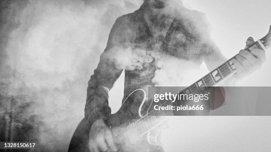 Rock guitarist playing guitar in a live show with stage lights Rock guitarist playing guitar in a live show with stage lights