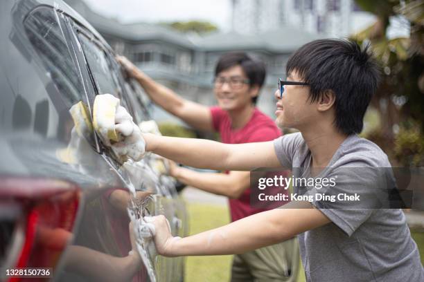 asian chinese father and son washing car at their backyard - teen wash car stock pictures, royalty-free photos & images