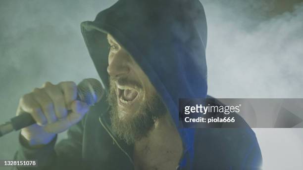 heavy metal rock sänger schreit in einer live-show mit bühnenlichtern - microphone mouth stock-fotos und bilder