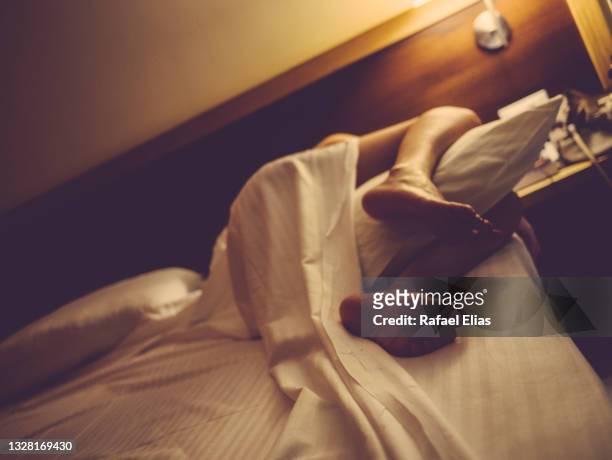 woman in bed embracing pillow with her legs - travesseiro imagens e fotografias de stock