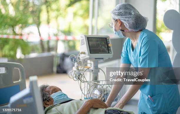 hospital with expert doctors takes care of all patients. hospitalized woman lying in bed while doctor checking his pulse. women physician examining females patient in hospital room. - pneumonia patient stock pictures, royalty-free photos & images