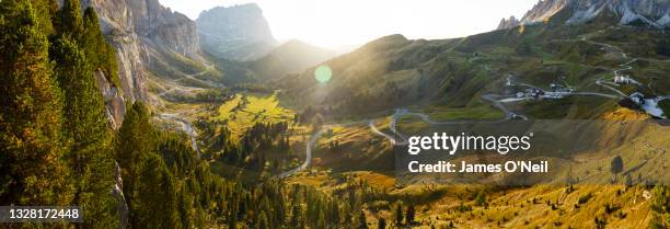winding road through mountain pass at sunset, dolomites, italy - bergpass stock-fotos und bilder
