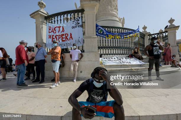 Demonstrator checks his cellphone during the gathering in Praça do Comercio to protest against current practices by SEF related to immigrants trying...