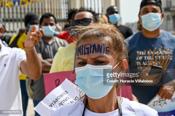 Mask-clad Brazilian immigrant takes part of the demonstration in Praça do Comercio to protest against current practices by SEF related to immigrants...