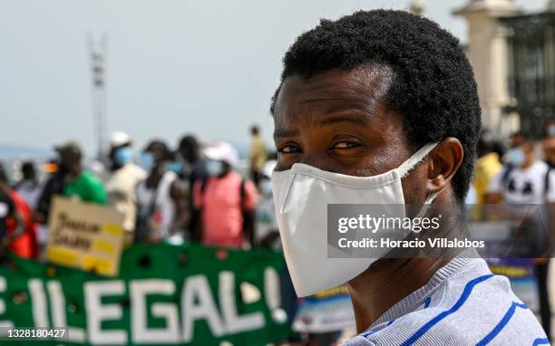 Mask-clad Angolan immigrant takes part of the demonstration in Praça do Comercio to protest against current practices by SEF related to immigrants...