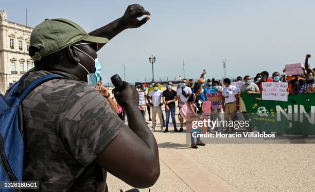 Mask-clad speaks to participants of the demonstration in Praça do Comercio to protest against current practices by SEF related to immigrants trying...