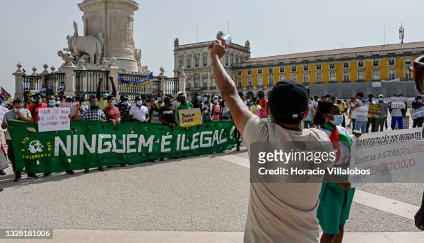 Mask-clad speaks to participants of the demonstration in Praça do Comercio to protest against current practices by SEF related to immigrants trying...