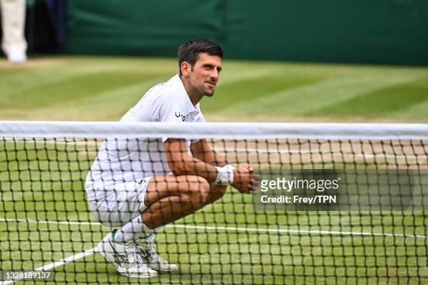 Novak Djokovic of Serbia eats some grass from centre court after beating Mateo Berrettini of Italy in the final of the gentlemen's singles during Day...