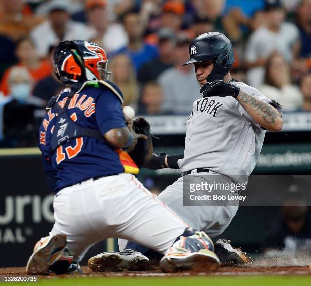 Gary Sanchez of the New York Yankees scores in the third inning as Martin Maldonado of the Houston Astros can't handle the throw at Minute Maid Park...