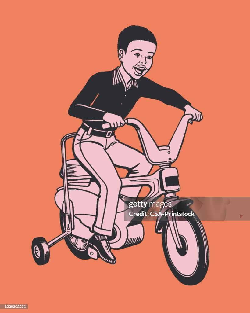 Boy riding bicycle with training wheels