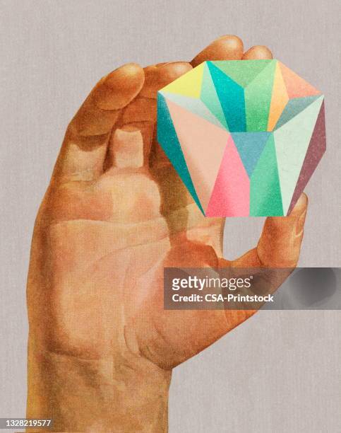 hand holding a colorful faceted rock - stone hand stock illustrations