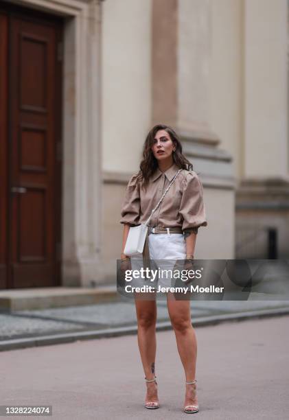 Masha Sedgwick wearing white YSL heels, white Mango denim shorts, Muse Copenhagen blouse and white Jil Sander bag on July 06, 2021 in Berlin, Germany.