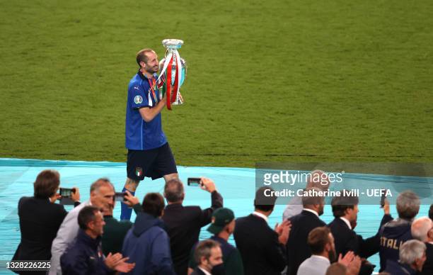 Giorgio Chiellini, Captain of Italy walks to the podium with The Henri Delaunay Trophy following his team's victory in the UEFA Euro 2020...