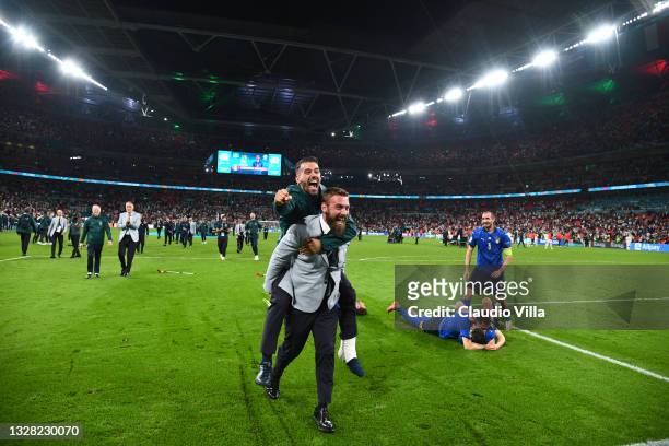 Leonardo Spinazzola of Italy jumps on the back of Daniele De Rossi, Assistant Coach of Italy as they celebrate their side's victory after the UEFA...