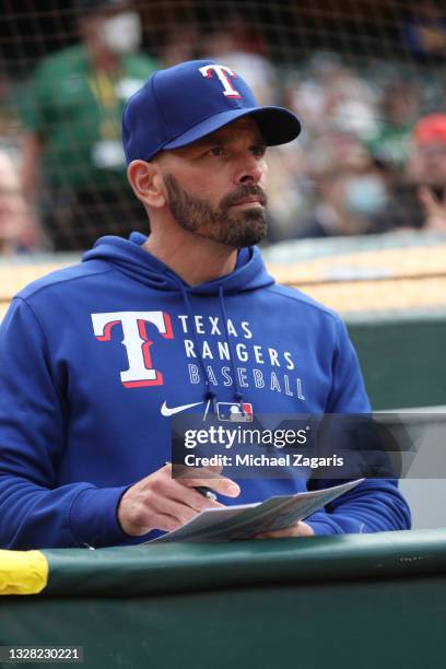 Manager Chris Woodward of the Texas Rangers in the dugout during the game against the Oakland Athletics at RingCentral Coliseum on June 30, 2021 in...