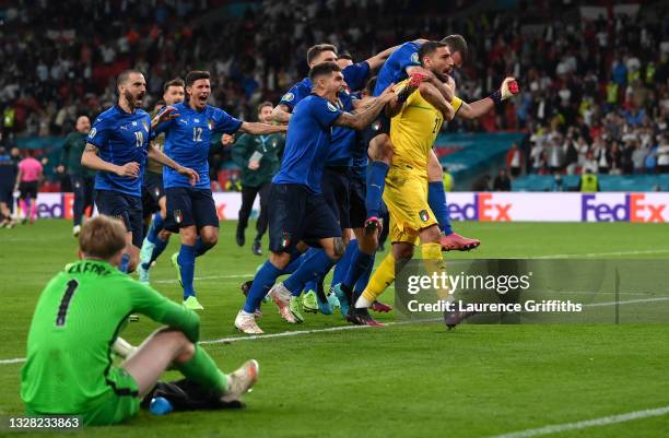 Gianluigi Donnarumma of Italy celebrates with teammates after saving the England fifth penalty taken by Bukayo Saka of England in a penalty shoot out...