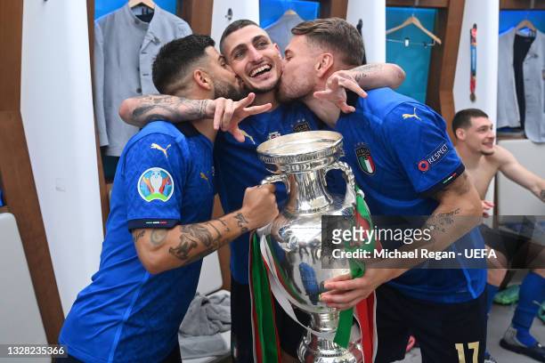 Lorenzo Insigne, Marco Verratti and Ciro Immobile of Italy celebrate with The Henri Delaunay Trophy in the dressing room following their team's...