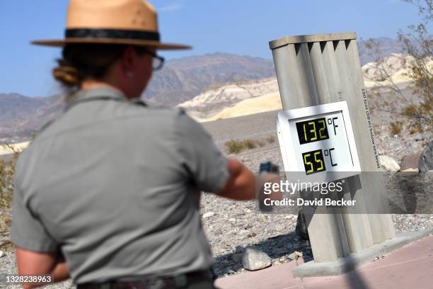 United States Park Ranger Jeannette Jurado takes a surface temperature reading from an unofficial thermometer reading 132 degrees Fahrenheit/55...