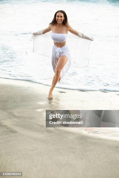 schönes brünettes mädchen mit langen haaren in weißem kleid bei sonnenuntergang stockfoto - bride running stock-fotos und bilder