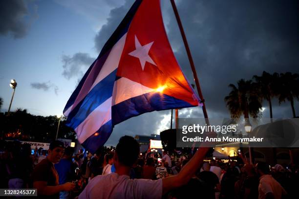 Man waves a Cuban flag in the street near of Versailles, a Cuban restaurant in the Little Havana neighborhood, at a demonstration in support of the...