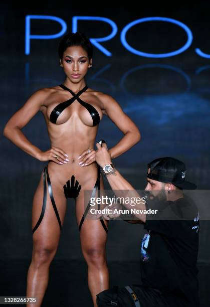 Designer Joel Alvarez tapes models on the runway at the BLACK TAPE PROJECT Show during Miami Swim Week Powered By Art Hearts Fashion at Faena Forum...