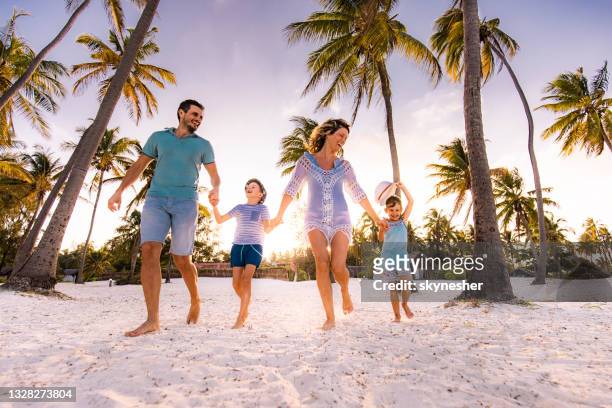 familia despreocupada corriendo en la playa. - playa fotografías e imágenes de stock