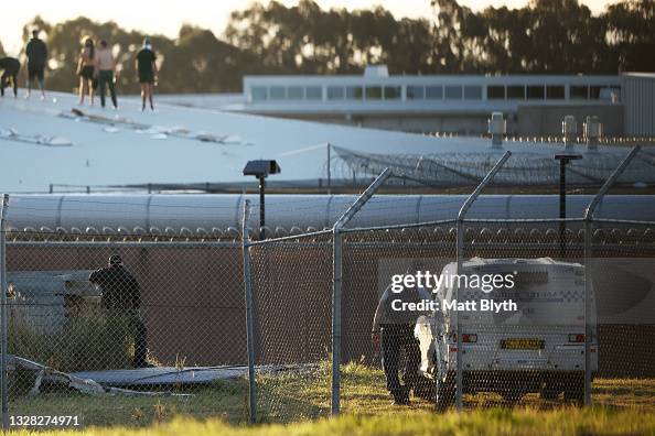 Police observe as prison inmates are seen rioting on the roof of ...