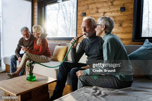 senior couples spending their time in the living room. - hookah stock pictures, royalty-free photos & images