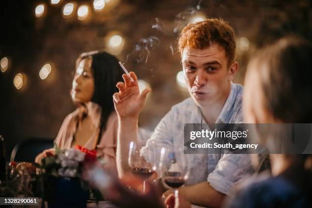 friends on dinner party in back yard - friends smoking stock pictures, royalty-free photos & images