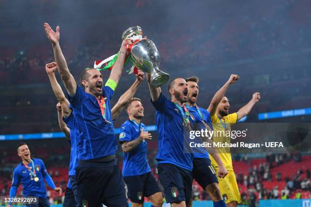 Giorgio Chiellini and Leonard Bonucci of Italy parade the trophy with team mates during the UEFA Euro 2020 Championship Final between Italy and...