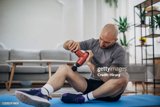 man massaging his leg - massager stock pictures, royalty-free photos & images