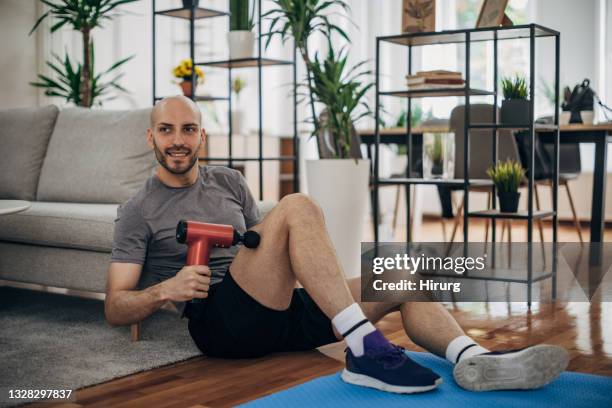 man massaging his leg - massager stock pictures, royalty-free photos & images