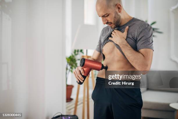 man massaging his abdomen - massager stock pictures, royalty-free photos & images