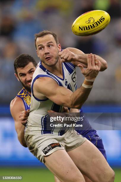 Josh Walker of the Kangaroos handballs against Jack Darling of the Eagles the round 17 AFL match between the West Coast Eagles and North Melbourne...
