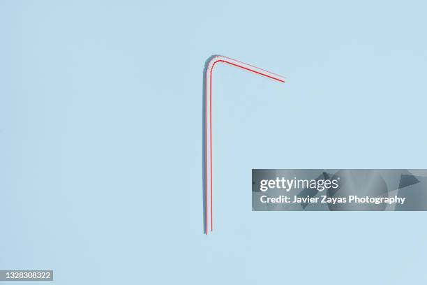 plastic straw on blue background - pajita fotografías e imágenes de stock