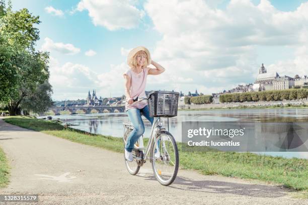 mature woman cycling loire valley, france - cycling loire valley stock pictures, royalty-free photos & images