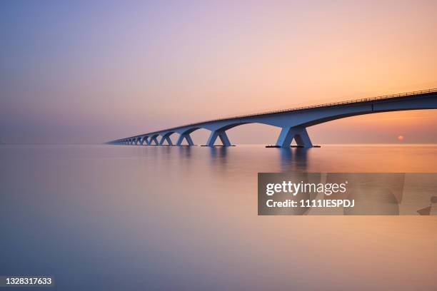 zeelandbrug during sunrise - brug mens gemaakte bouwwerken stockfoto's en -beelden