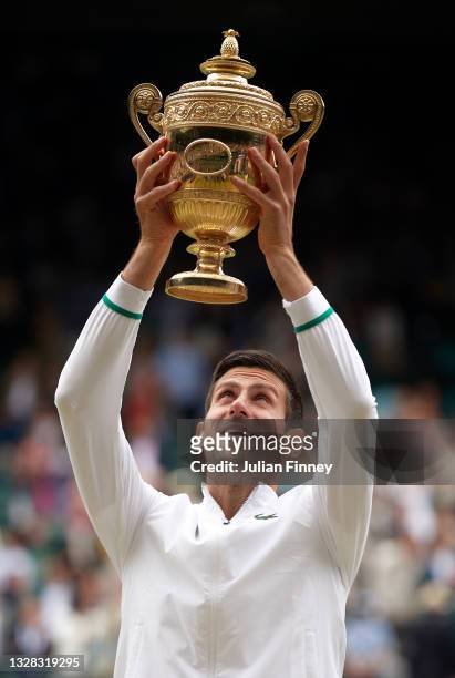 Novak Djokovic of Serbia celebrates with the trophy after winning his men's Singles Final match against Matteo Berrettini of Italy on Day Thirteen of...