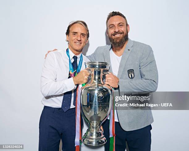 Roberto Mancini, Head Coach of Italy and Daniele De Rossi, Assistant Coach of Italy pose with The Henri Delaunay Trophy during an Italy Portrait...