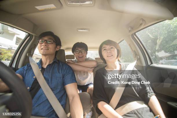 padres chinos asiáticos y su hijo disfrutando mientras viajan en coche. la vista es a través del parabrisas. - family inside car fotografías e imágenes de stock